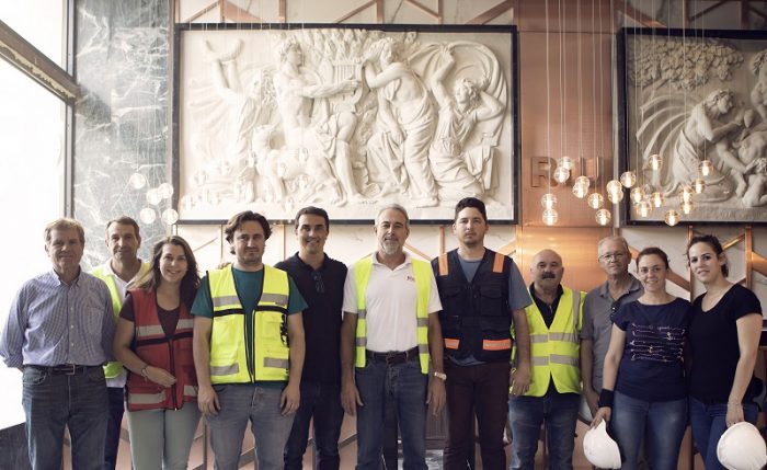 Luis Riu, con parte del equipo participante en las obras del Riu Plaza España, ante el bajo relieve original de la recepción