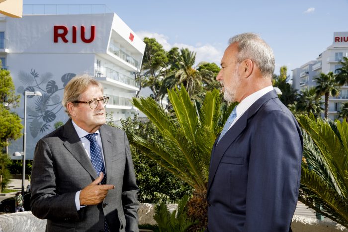 Luis Riu und Félix Casado unterhalten sich neben zwei der RIU Hotels in Palma.