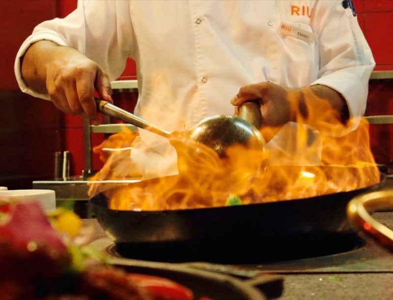 Der Küchenchef bereitet ein Gericht vor Ort in einem Restaurant des All-Inclusive-Hotels Riu Dubai zu