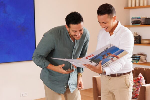 The brothers Roberto and Luis Riu Rodríguez looking at an old RIU Hotels & Resorts magazine