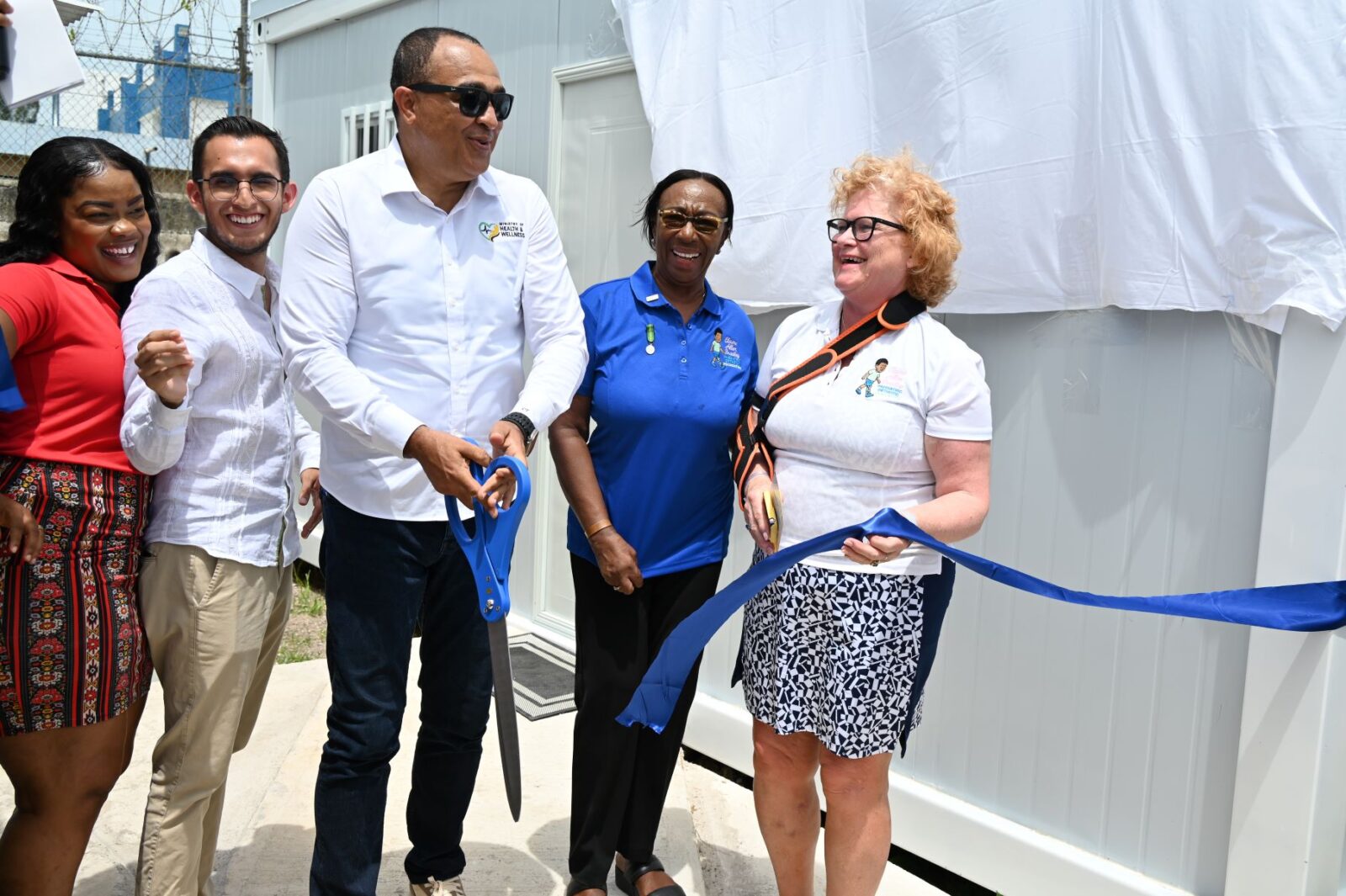 El ministro de Salud y Bienestar de Jamaica, Christopher Tufton, cortando la cinta para inaugurar el nuevo servicio de fisioterapia
