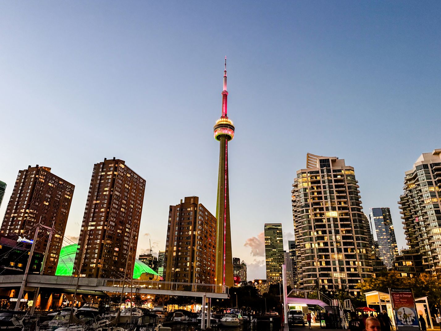 Blick auf das Stadtzentrum von Toronto (Kanada) bei Dämmerung, mit leuchtenden Wolkenkratzern und dem CN Tower