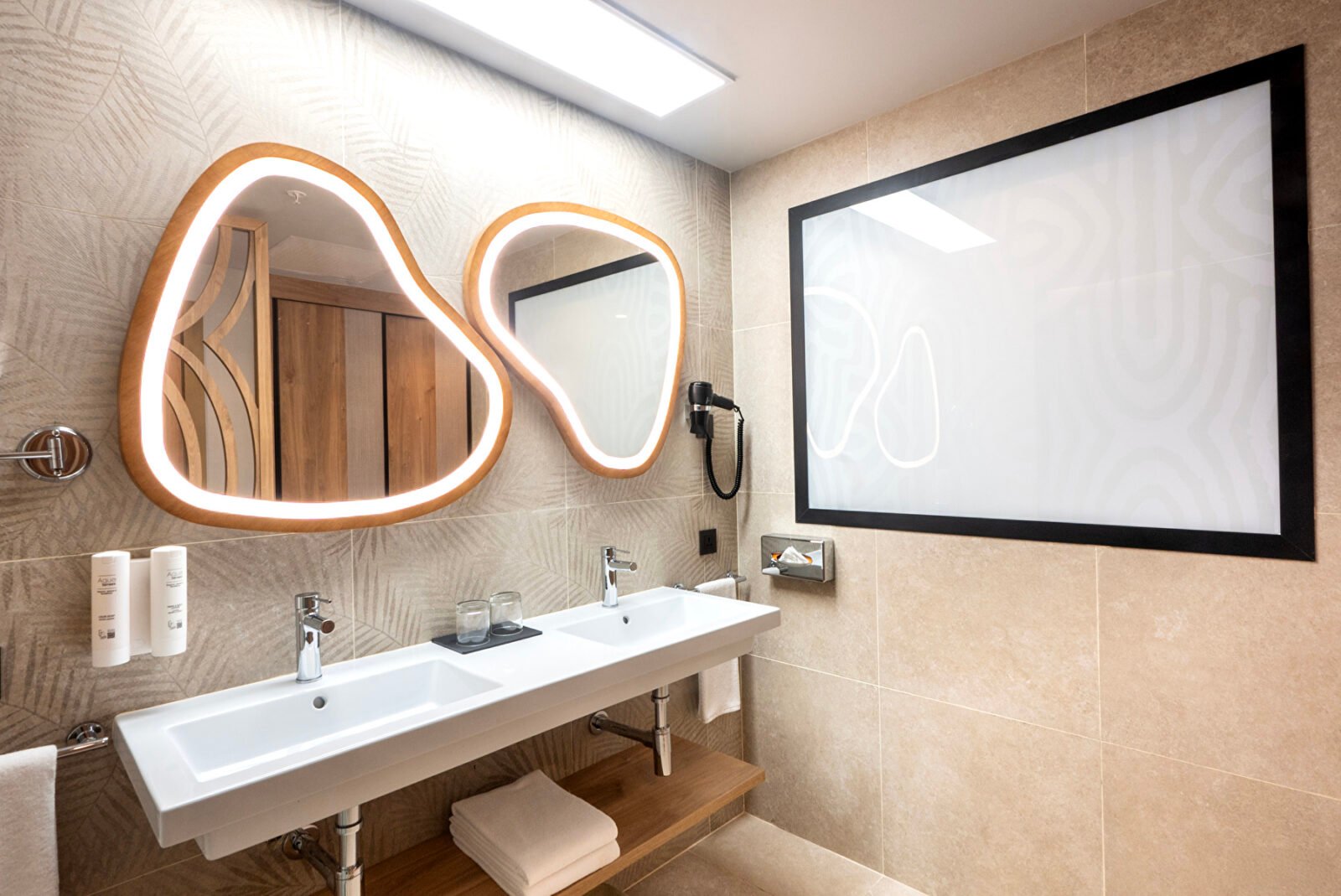 Badezimmer einer Junior Suite im Riu Palace Swahili mit Doppelwaschbecken und beleuchteten Spiegeln