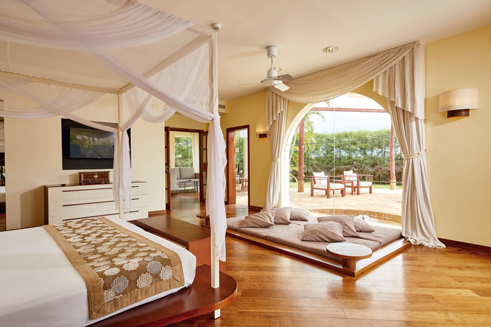 Innenansicht einer Villa im Hotel Riu Palace Zanzibar mit Himmelbett, Wohnbereich und Terrasse