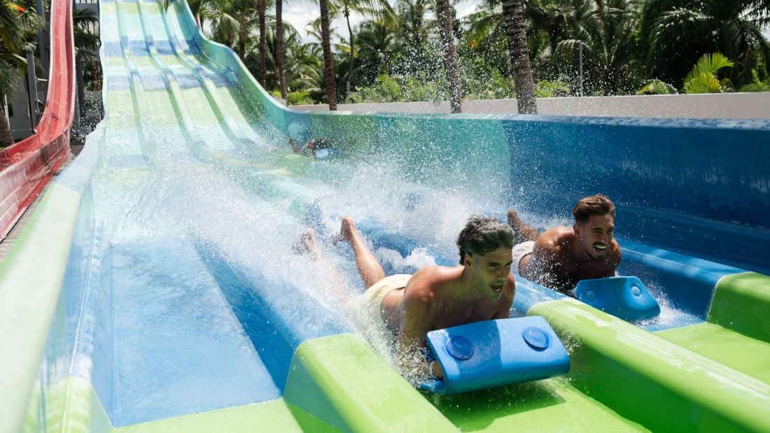 Dos personas disfrutan lanzándose de un tobogan del Splash Water World de RIU