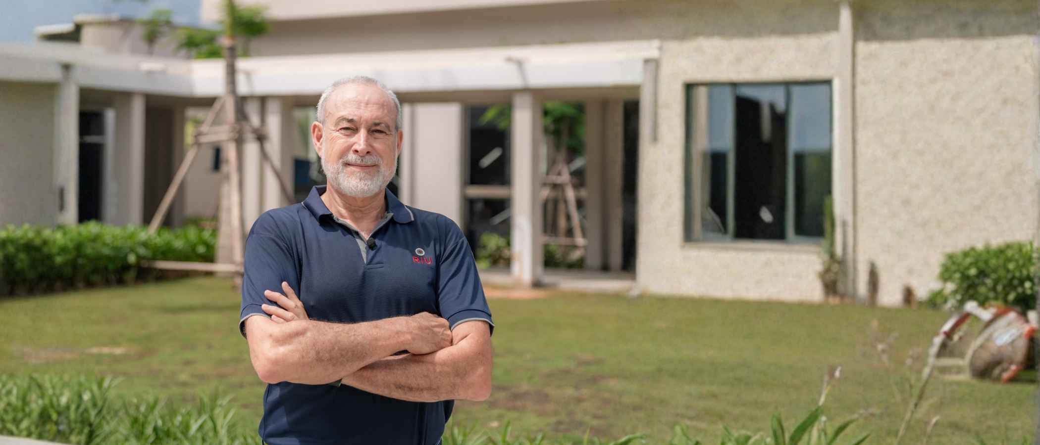 Retrato de Luis Riu, CEO de RIU, con el hotel Riu Palce Phuket difunido de fondo.