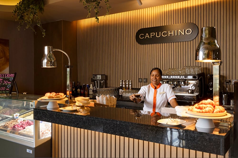 A waitress prepares a dish at the Riu Palace Aruba's Capuchino bar.