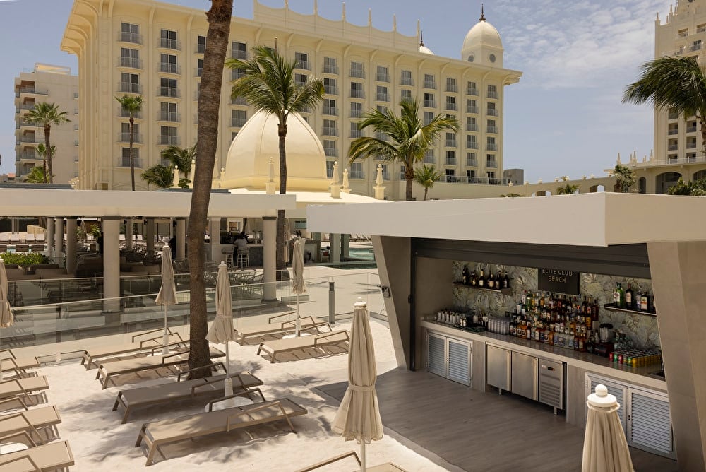 Wide shot showing the exclusive Elite Club bar outdoors in broad daylight.