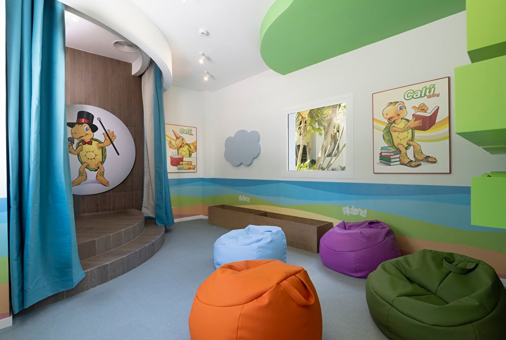 Vista lateral del club infantil RIU Land, en el Riu Palace Aruba. Se ve la parte lateral del mini teatro con distintos cojines que funcionan de asientos para los niños.