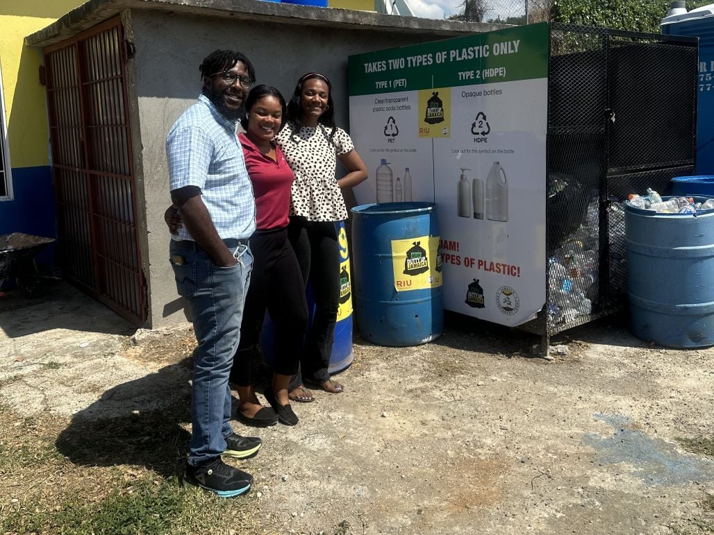 three member of JET smaily and standing with recycled bins in Jamaica