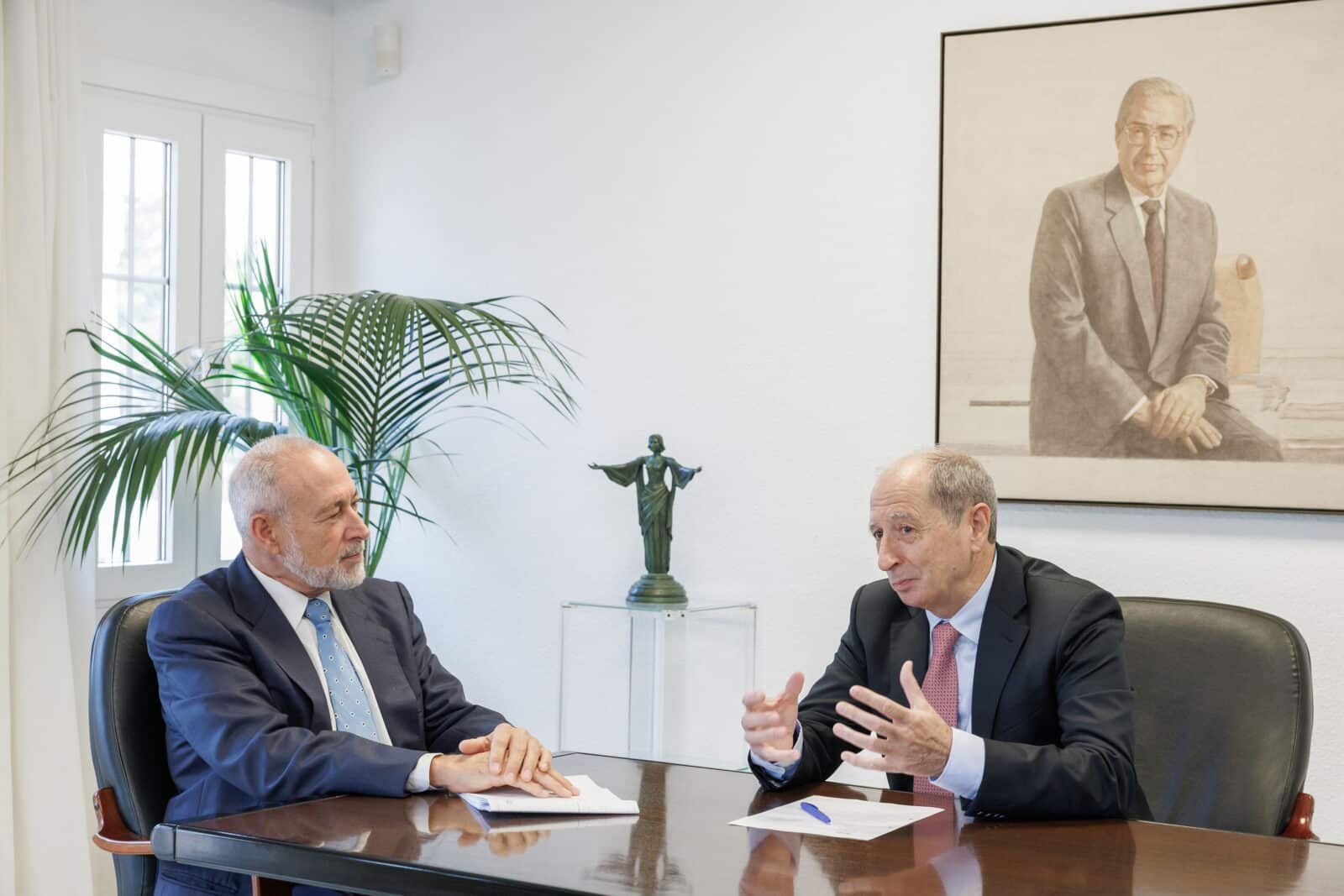 Luis Riu y Fernando García conversan en una sala de reuniones de RIU, con un retrato al óleo al fondo