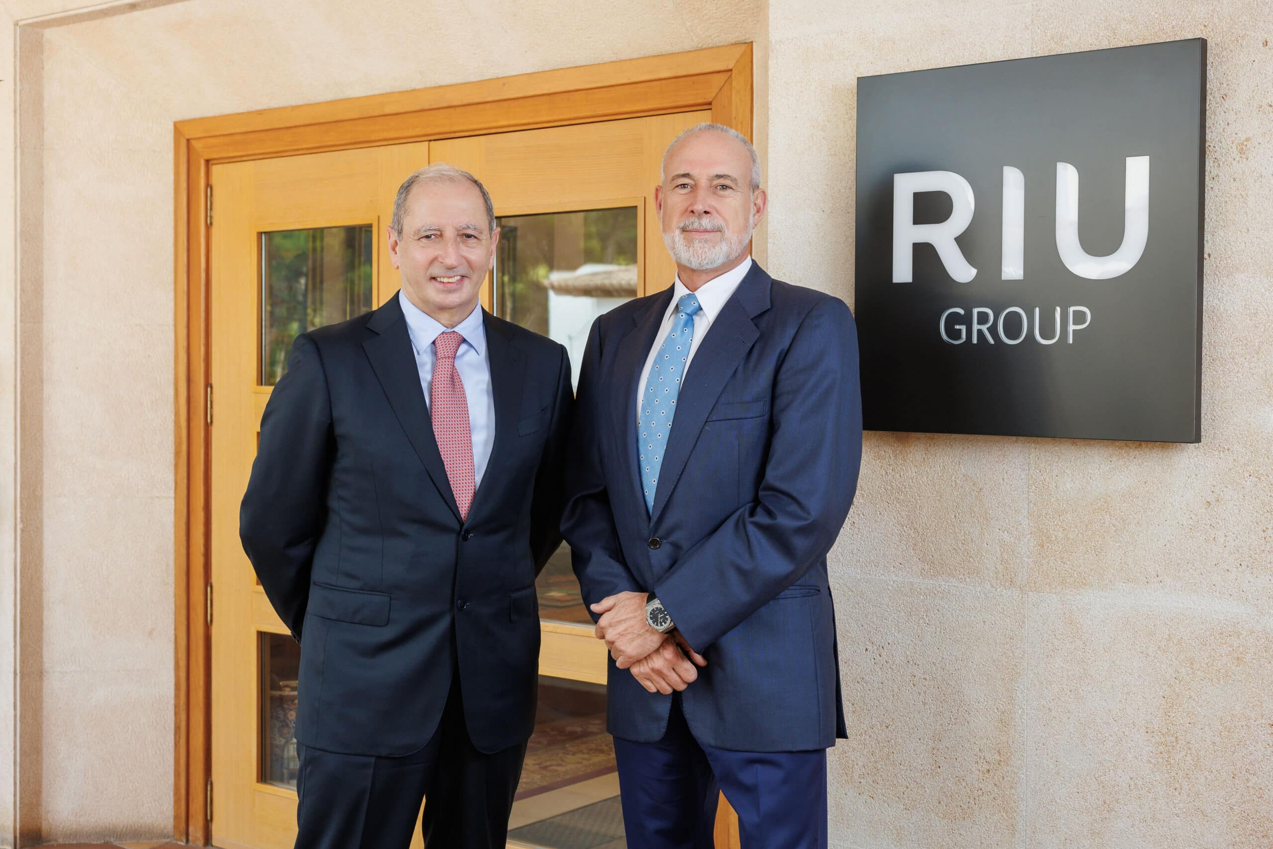 Luis Riu, CEO de RIU Hotels & Resorts, y Fernando García, Consejero Directivo de RIU, junto al rótulo de RIU Group